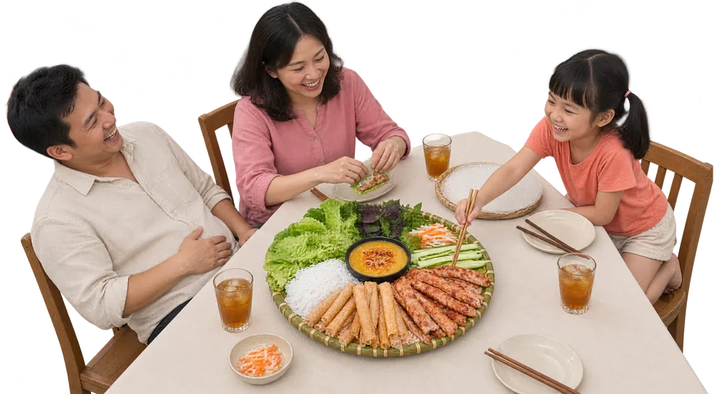 Bố, mẹ và con gái cười vui quanh bàn ăn, cùng cuốn nem nướng Luji với rau sống và bánh tráng