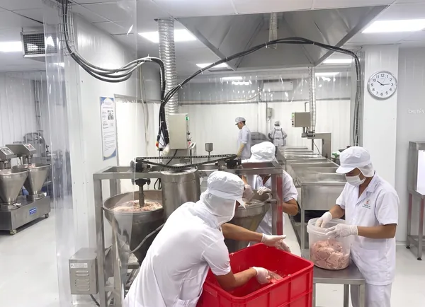Công nhân mặc đồ bảo hộ trắng làm việc trong phòng sạch của xưởng
