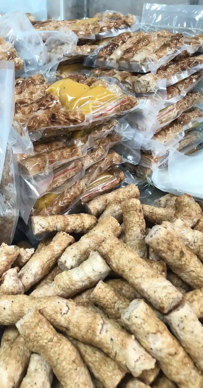 Những túi nem đã hút chân không xếp chồng tại xưởng, phía trước là nem đã nướng chưa đóng túi