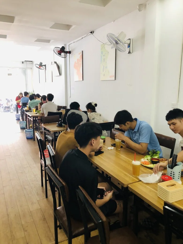 Dãy bàn dài dọc tường, khách ngồi ăn nem