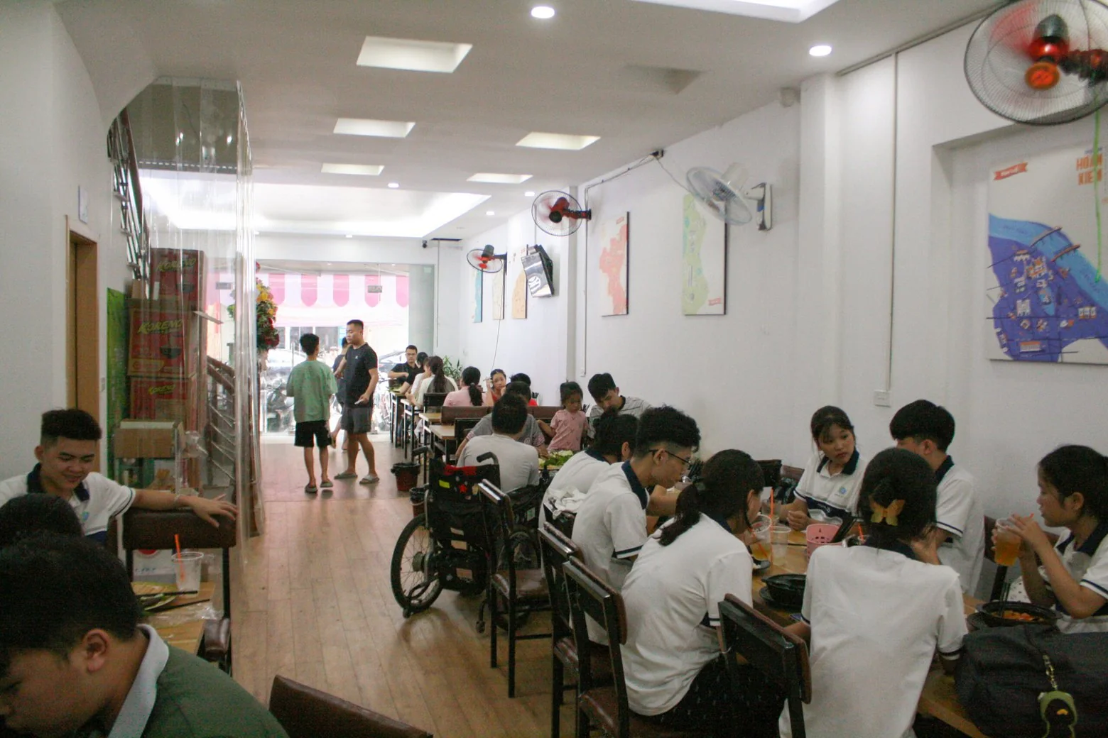 Quán đông khách, nhiều bàn học sinh áo trắng ngồi ăn