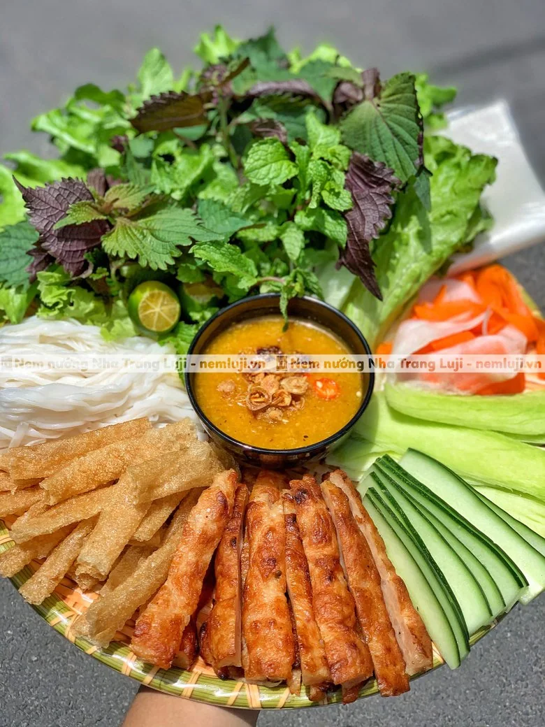 Mâm nem nướng cận cảnh: nem, ram cuốn, rau sống, chén nước chấm