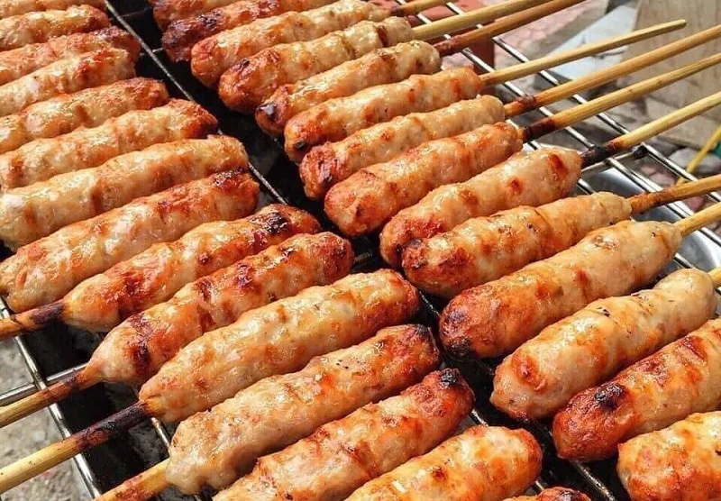 Nem nướng xiên que đang nướng trên vỉ than, vàng đều